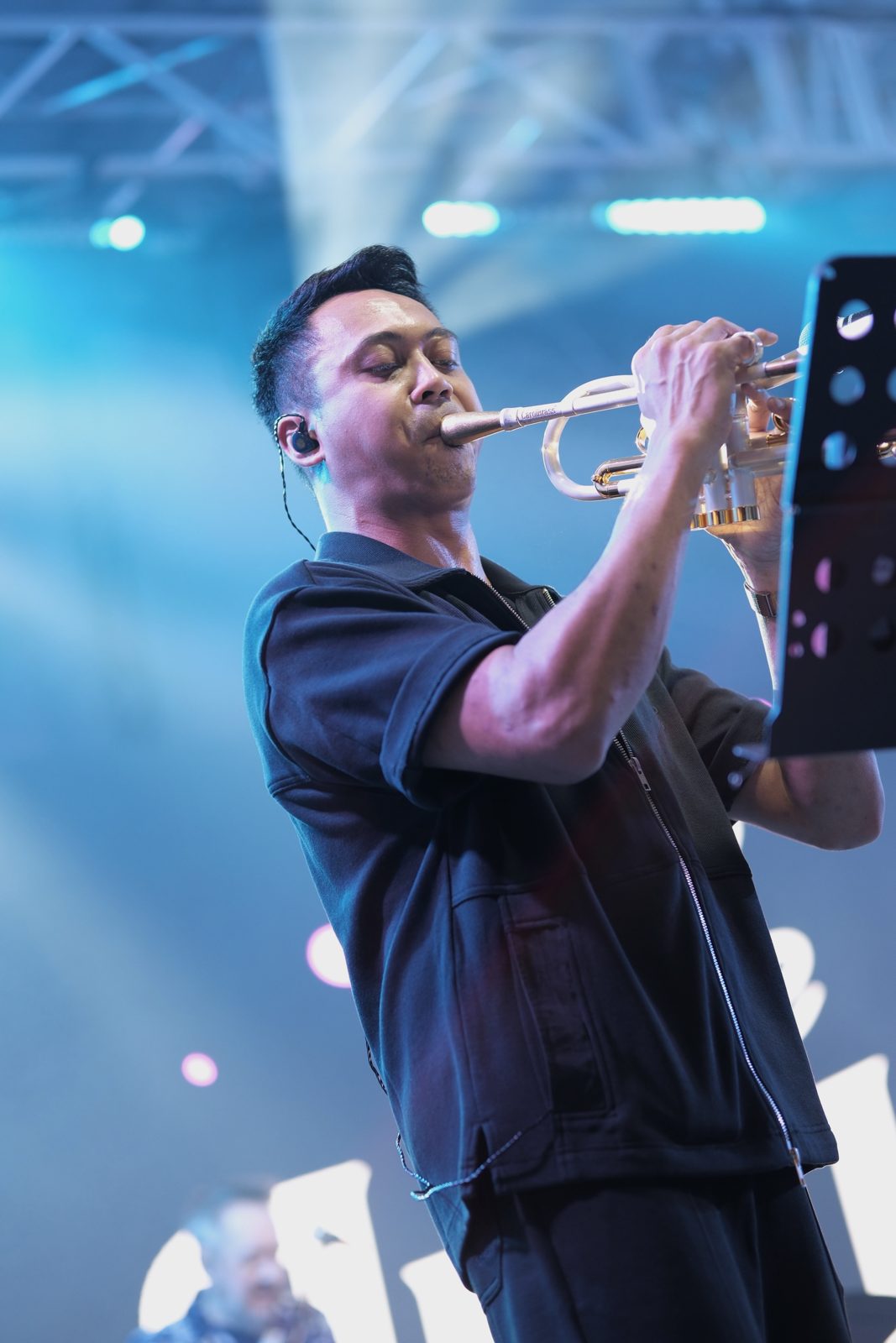 Farhan of The Jukuleles playing trumpet on stage