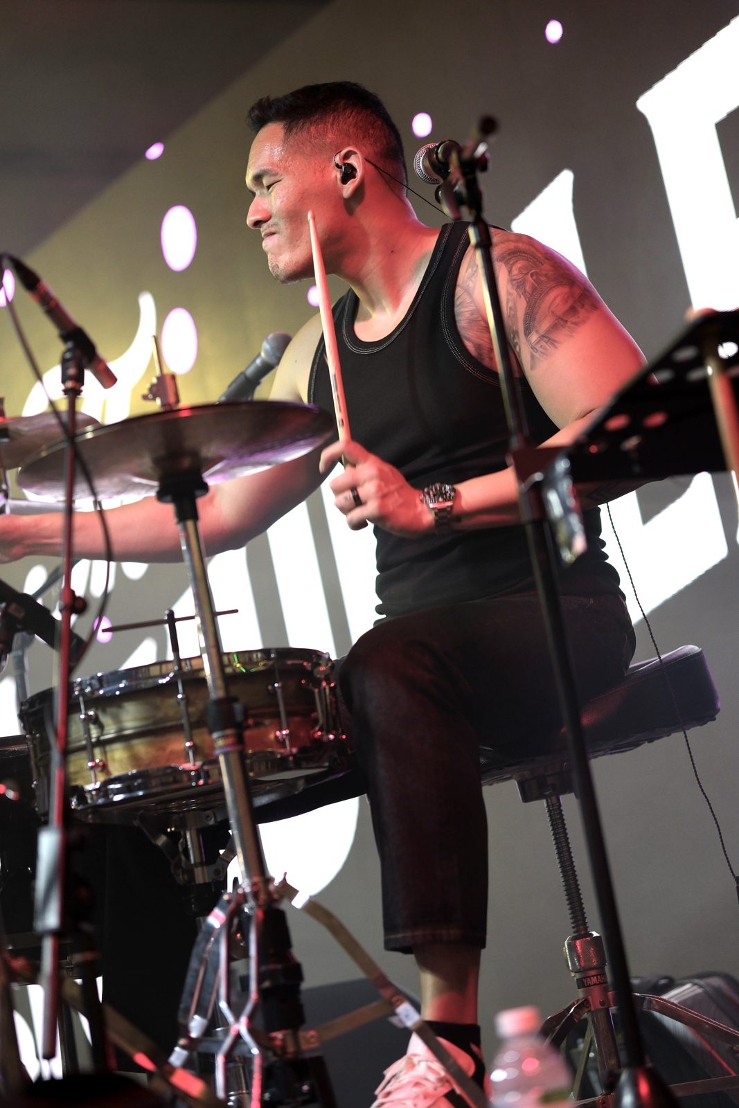 Zi of The Jukuleles playing drums at a festival